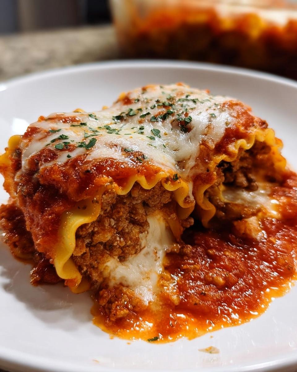 A close-up of a delicious slice of Cheesy Lasagna Roll-Ups, topped with melted mozzarella and parsley.