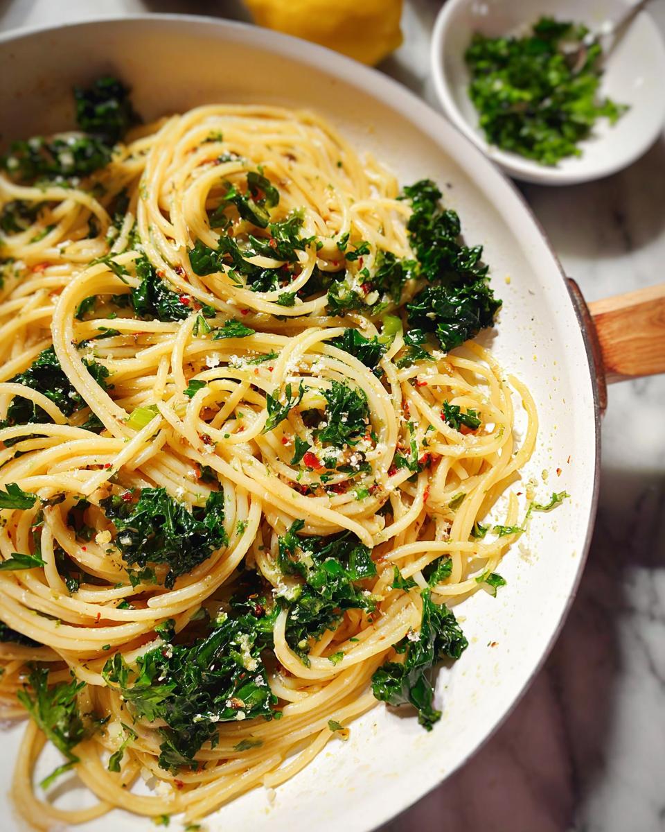 A close-up of Spaghetti Aglio e Olio in a pan, tossed with garlic, chili flakes, and fresh parsley.