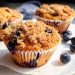 Close-up of a delicious Blueberry Muffin Like a Bakery, featuring a generous streusel topping and fresh blueberries.