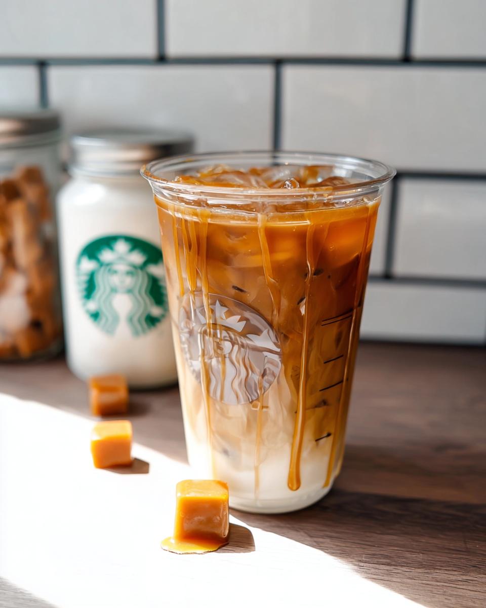 A plastic cup filled with an Iced Caramel Macchiato copycat drink, featuring layered milk and espresso, topped with caramel drizzle.