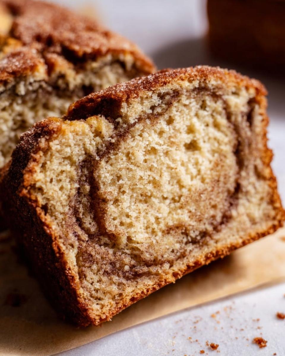 A close-up shot showing the moist interior and rich cinnamon swirl pattern of Cinnamon Swirl Banana Bread.