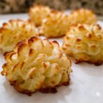 Close-up of perfectly piped and baked Duchess Potatoes (Make Ahead) with golden, crispy edges.