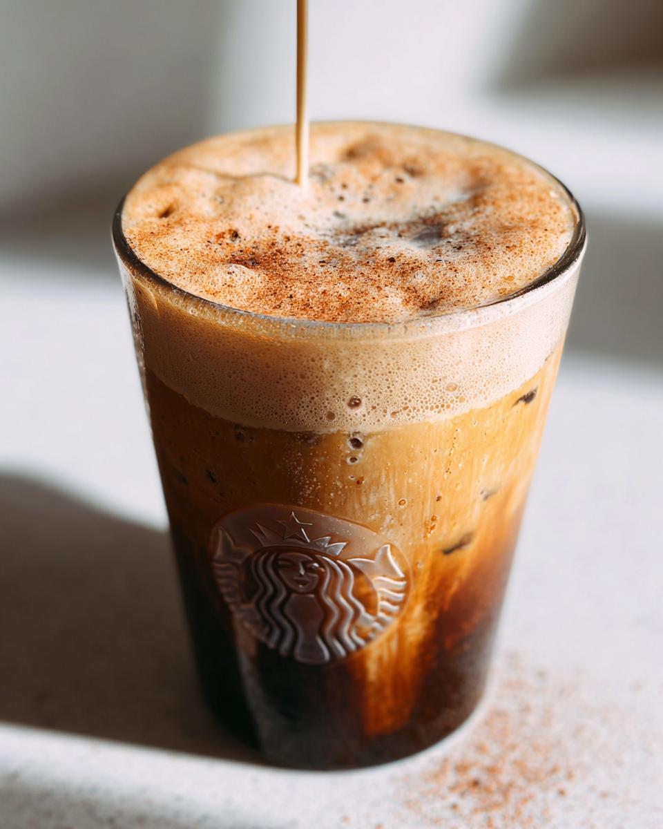 Close-up of espresso being poured over ice and oatmilk to make an Iced Brown Sugar Oatmilk Shaken Espresso.