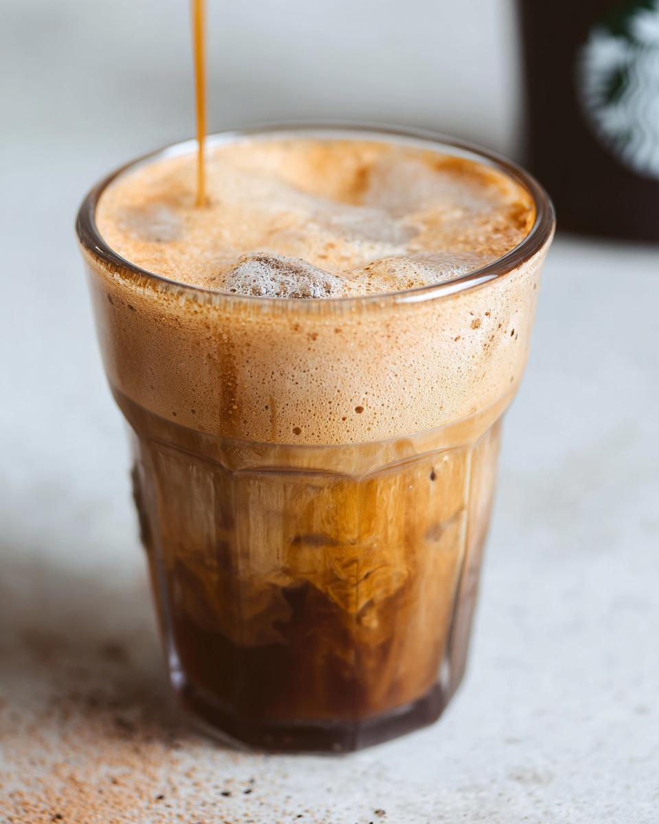 Close-up of espresso being poured over ice and oatmilk to make an Iced Brown Sugar Oatmilk Shaken Espresso.