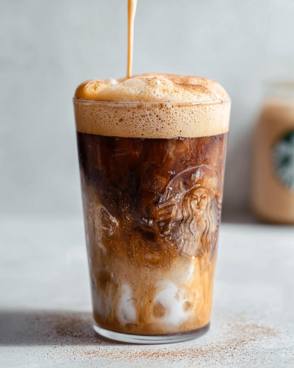 Close-up of Iced Brown Sugar Oatmilk Shaken Espresso being topped with foamy espresso.