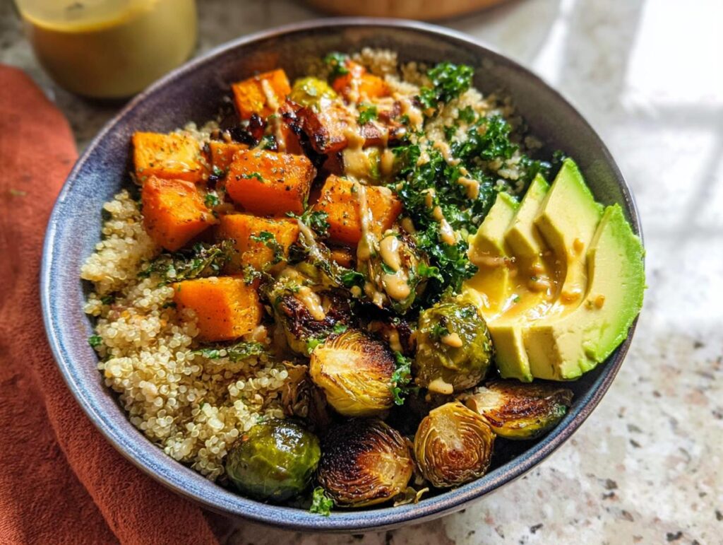 A vibrant Quinoa and Veggie Power Bowl featuring roasted butternut squash, Brussels sprouts, kale, avocado slices, and a drizzle of dressing.