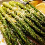 A close-up of bright green Roasted Asparagus with Parmesan cheese and lemon zest.