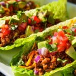 Close-up of fresh Turkey Taco Lettuce Wraps filled with seasoned ground turkey, avocado, tomato, and red onion.