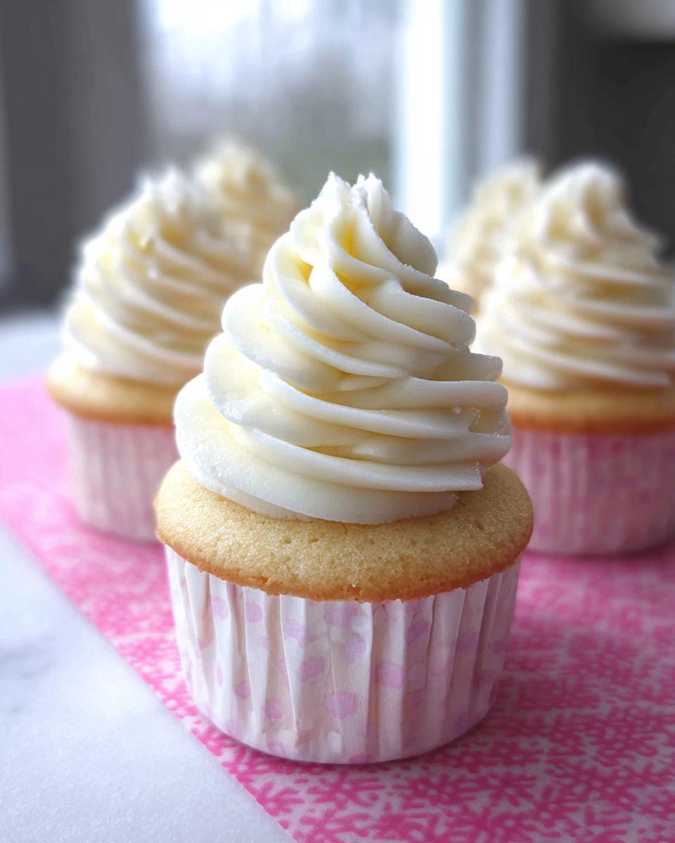 Close-up of a delicious Vanilla Cupcake topped with swirls of creamy Buttercream frosting.
