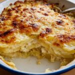 Close-up of a baked Creamy Potato Leek Gratin with a deeply browned, cheesy crust, showing layers of potatoes and leeks.