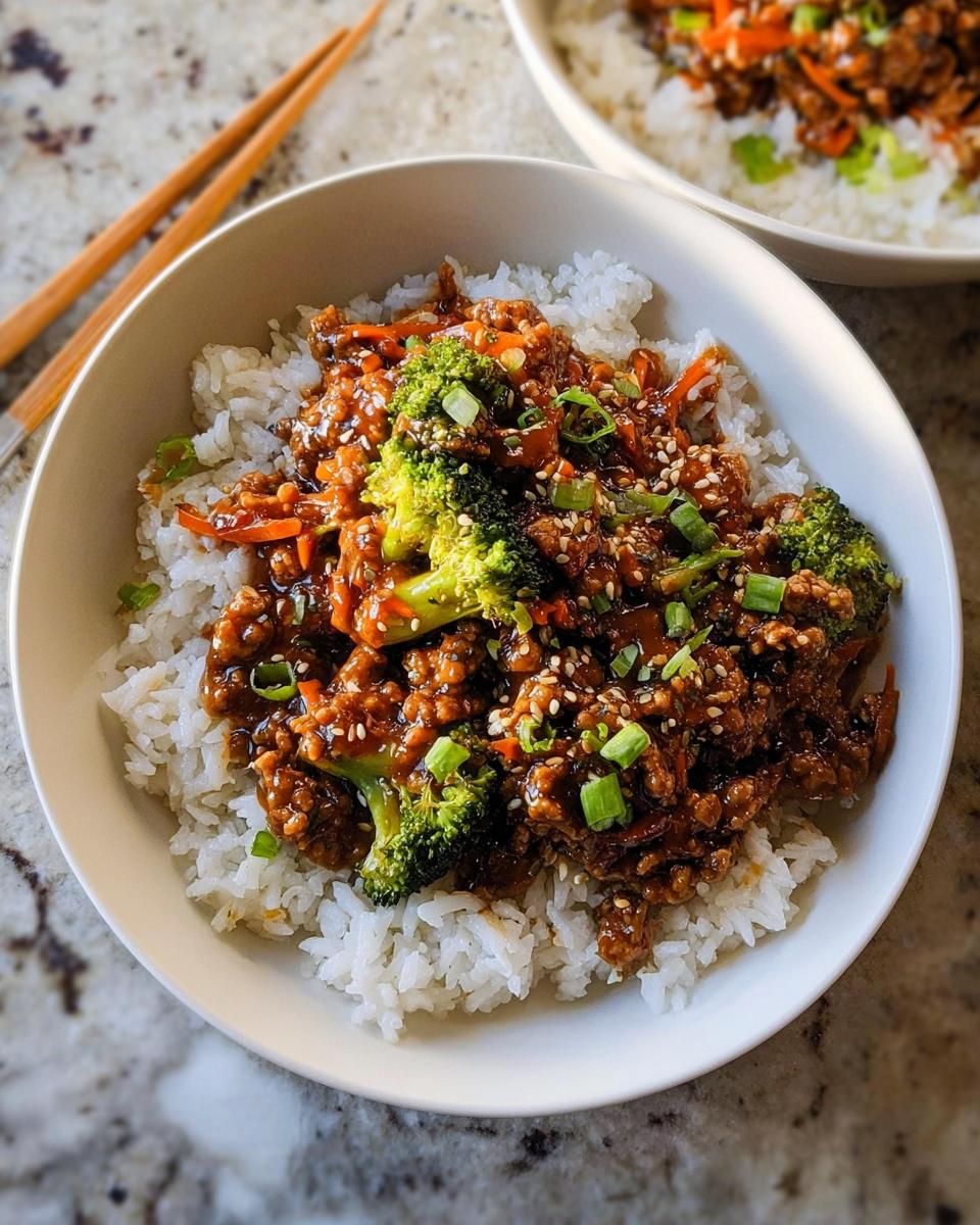 A close-up of a bowl of Healthy College Lunch Ideas: Ground Turkey Teriyaki Stir-Fry served over white rice, garnished with broccoli and sesame seeds.