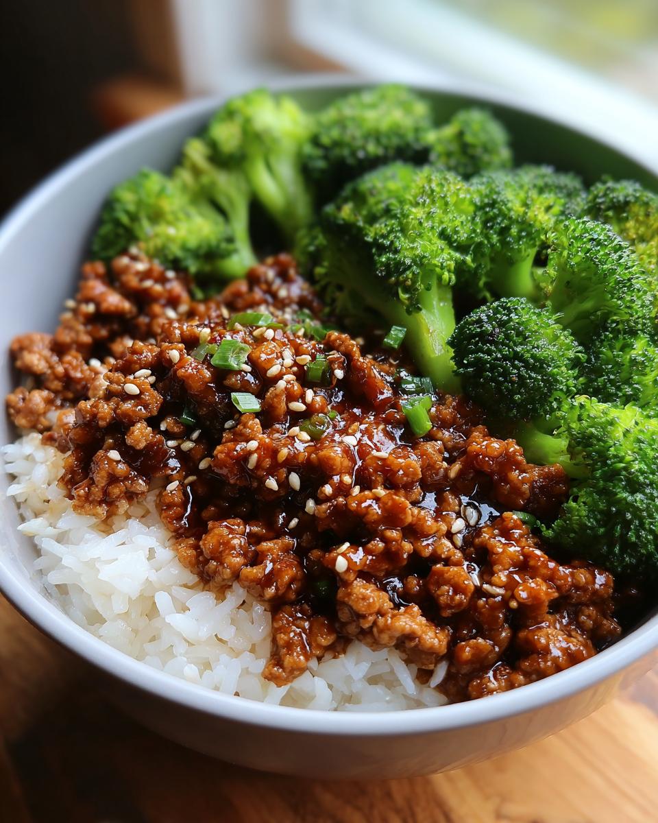 A bowl of Healthy Honey Garlic Ground Turkey Recipes served over white rice with steamed broccoli.