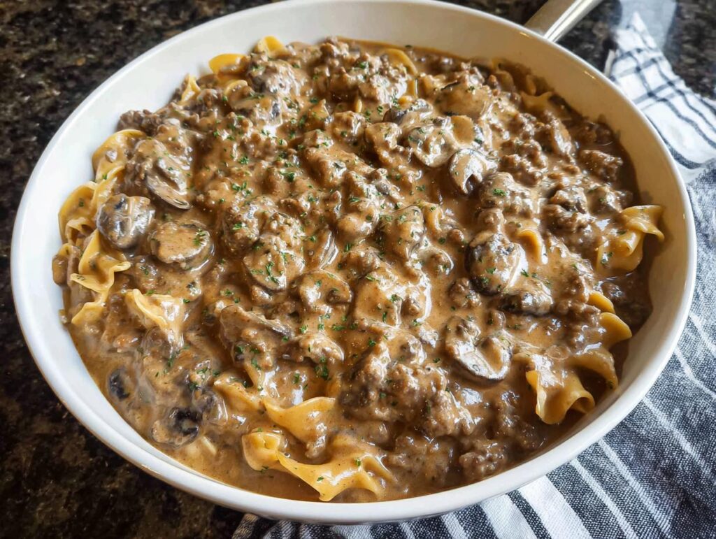 Close-up of creamy One Pot Ground Beef Stroganoff with egg noodles and mushrooms, garnished with parsley.