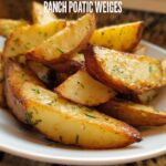 Close-up of golden brown Roasted Ranch Seasoned Potato Wedges sprinkled with green herbs in a white bowl.