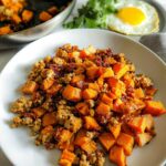 A serving of Turkey and Sweet Potato Skillet Hash featuring diced orange sweet potatoes and ground turkey mixture on a white plate.