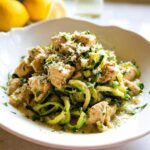 A serving of Zucchini Noodle Chicken Alfredo Lightened Up with chunks of chicken and grated parmesan.
