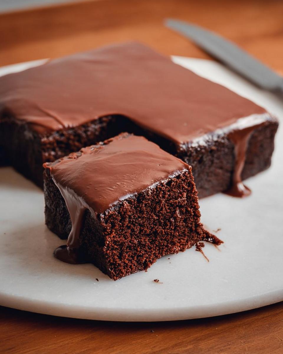 Close-up of a rich, moist chocolate cake slice with dripping ganache, illustrating one of the best cake ideas recipes.