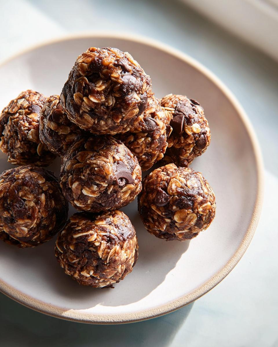 A stack of chocolate oat energy bites, perfect for quick breakfast ideas recipes, on a light ceramic plate.