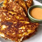 Close-up of crispy cheese tacos (quesadillas) served with a side of orange dipping sauce for Restaurant-Style Taco Tuesday Recipes at Home.