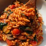 Close-up of fusilli pasta tossed in a rich tomato sauce with zucchini, cherry tomatoes, and mushrooms—a perfect easy dinner recipe.
