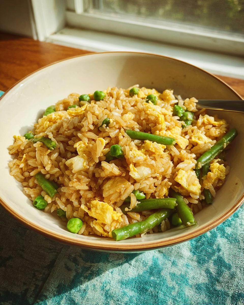 A bowl of simple egg fried rice with green beans and peas, perfect for 7-Ingredient Egg Recipes.
