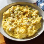 A plate of fluffy scrambled eggs topped with crumbled feta cheese and black pepper, a perfect example of the only egg recipes you'll need.