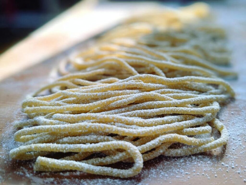 Close-up of fresh, hand-rolled pasta dusted with flour, ready for cooking in pasta recipes like a pro.