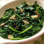 Close-up of vibrant, glossy sautéed spinach with sliced garlic, perfect for 20-Ingredient Veggie Sides Recipes.