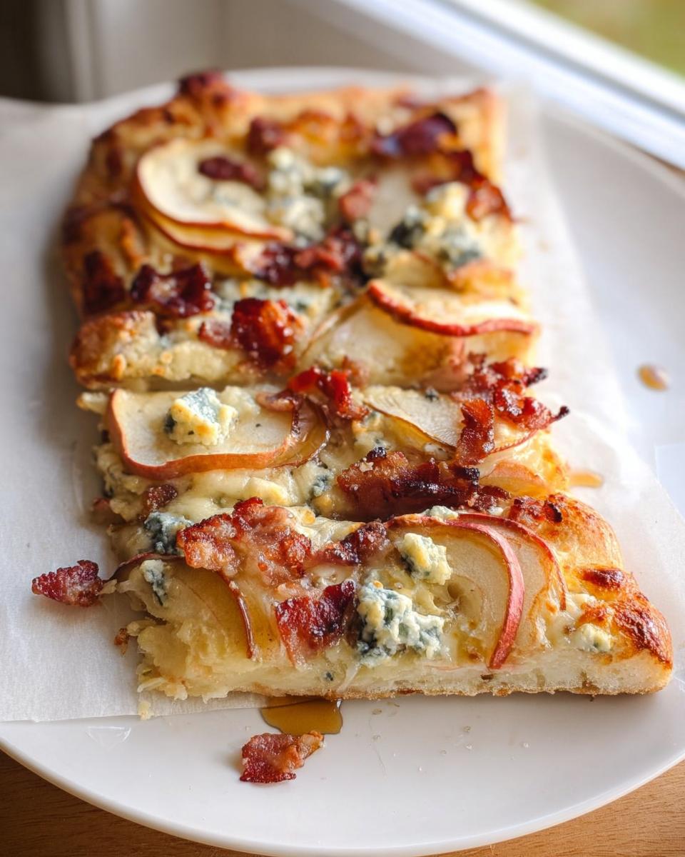 Close-up of a gourmet pizza slice topped with apples, blue cheese, and bacon, perfect for 10-Ingredient Pizza Night Recipes.