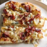 Slices of gourmet pizza topped with pear, bacon, blue cheese, and drizzled with honey, part of 10-Ingredient Pizza Night Recipes.