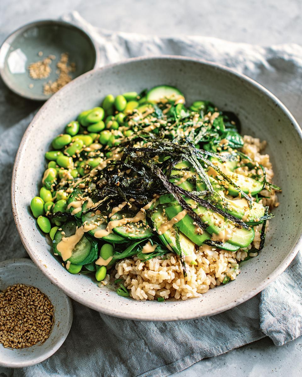 A vibrant vegan rice bowl featuring brown rice, edamame, avocado, cucumber, and seaweed strips, part of The Ultimate Rice Bowls Recipes Guide for Beginners.