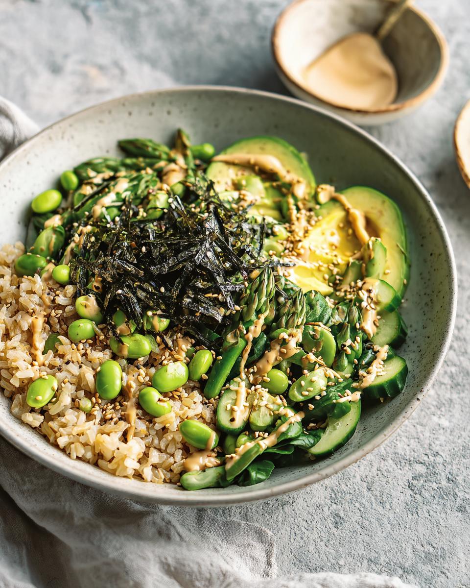 Close-up of a vibrant green vegetable rice bowl featuring brown rice, avocado, edamame, and seaweed, part of The Ultimate Rice Bowls Recipes Guide for Beginners.