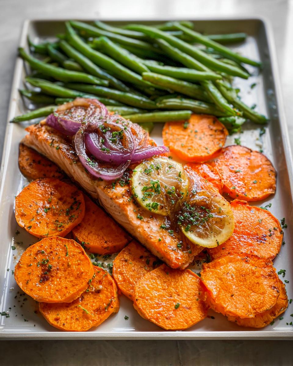 A perfectly cooked salmon fillet topped with caramelized red onion and lemon slices, served with roasted sweet potato rounds and green beans, ideal for Salmon Recipes Meal Prep.