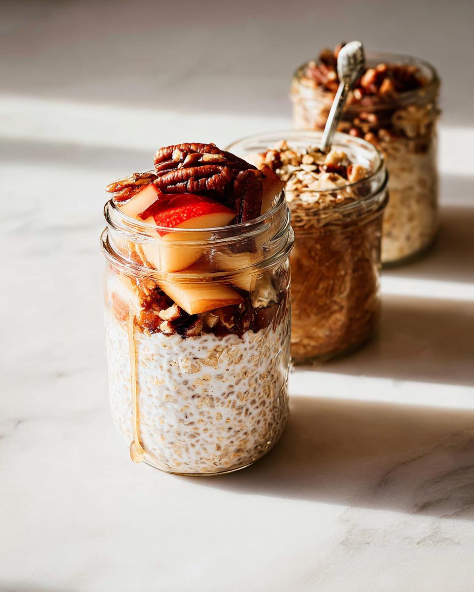 Three jars of overnight oats, a perfect example of healthy meals recipes, topped with apples and pecans.