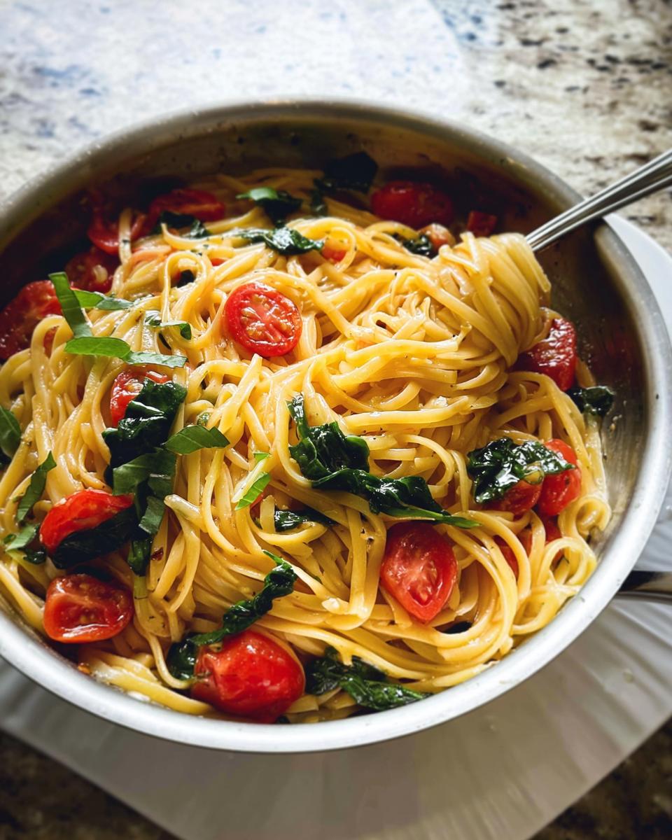 Close-up of linguine pasta tossed with halved cherry tomatoes and fresh basil, ready for Easy Dinner Recipes Meal Prep.