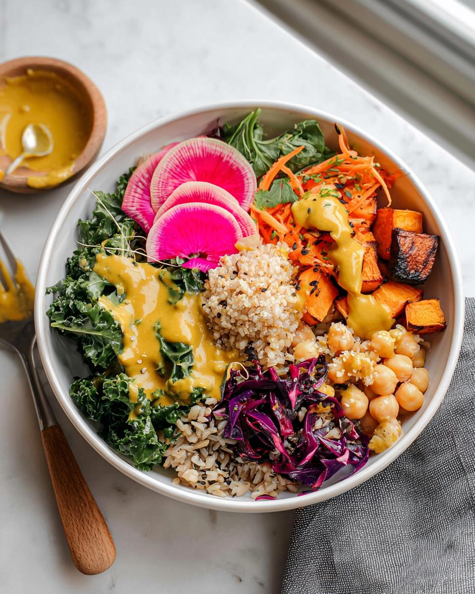A vibrant, fully loaded rice bowl featuring brown rice, kale, roasted sweet potatoes, chickpeas, and bright pink watermelon radish slices.