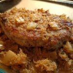Close-up of a perfectly seared pork chop recipe in 10 minutes served over a bed of caramelized onions.