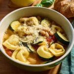 A bowl of hearty tortellini soup with zucchini, white beans, and Parmesan cheese, perfect for busy weeknights.