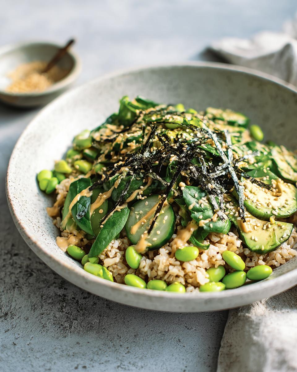 A vibrant vegetarian rice bowl featuring brown rice, edamame, spinach, avocado, and nori strips, part of The Ultimate Rice Bowls Recipes Guide.