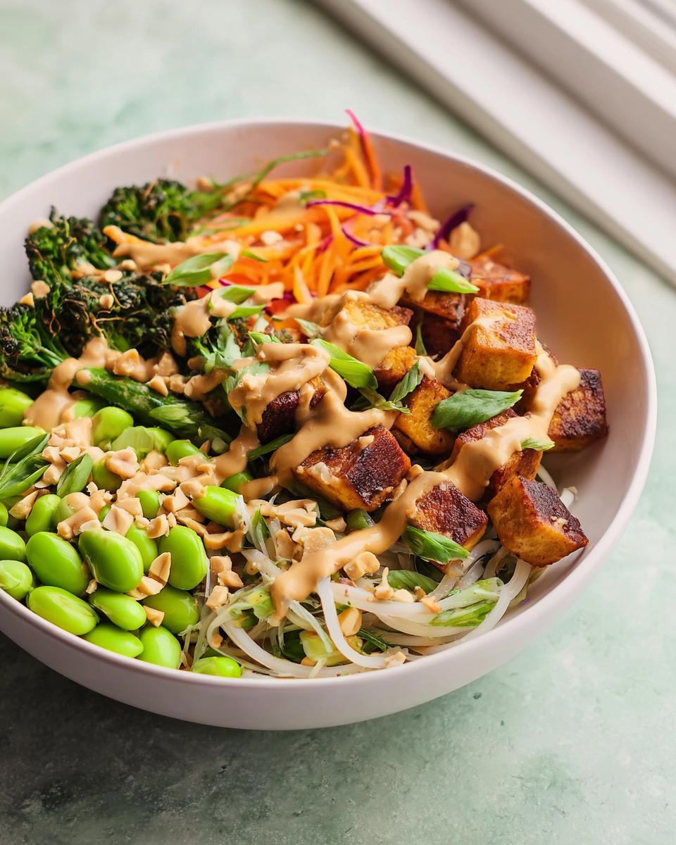 A colorful bowl featuring crispy tofu, edamame, roasted broccoli, and peanut sauce, perfect for 20-Ingredient Rice Bowls Recipes.