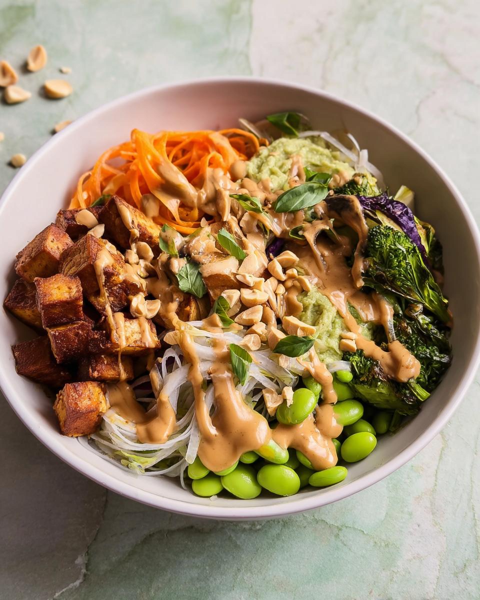 A colorful vegan rice bowl featuring crispy tofu, edamame, carrot noodles, and peanut sauce, part of 20-Ingredient Rice Bowls Recipes.