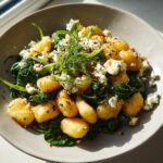 A bowl of Creamy Gnocchi with Spinach and Feta, topped with crumbled feta cheese and fresh dill.