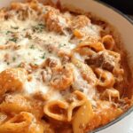 Close-up of baked Creamy High Protein Beef Pasta topped with melted mozzarella cheese and parsley.