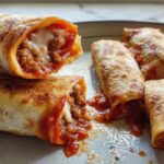 Close-up of two HIGH PROTEIN Pepperoni Pizza Rolls cut open showing melted cheese and savory filling.