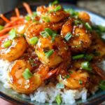 Close-up of Irresistible Honey Garlic Shrimp Bowls featuring glazed shrimp over white rice, topped with green onions.