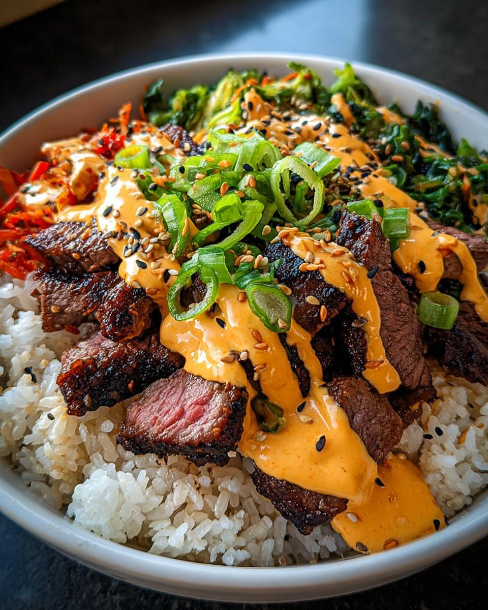 Close-up of Korean BBQ Steak Rice Bowls topped with spicy cream sauce, green onions, and sesame seeds.