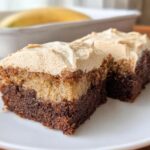 Two slices of Banana Bread Brownies Made Easy, layered with chocolate and banana bread, topped with creamy frosting.