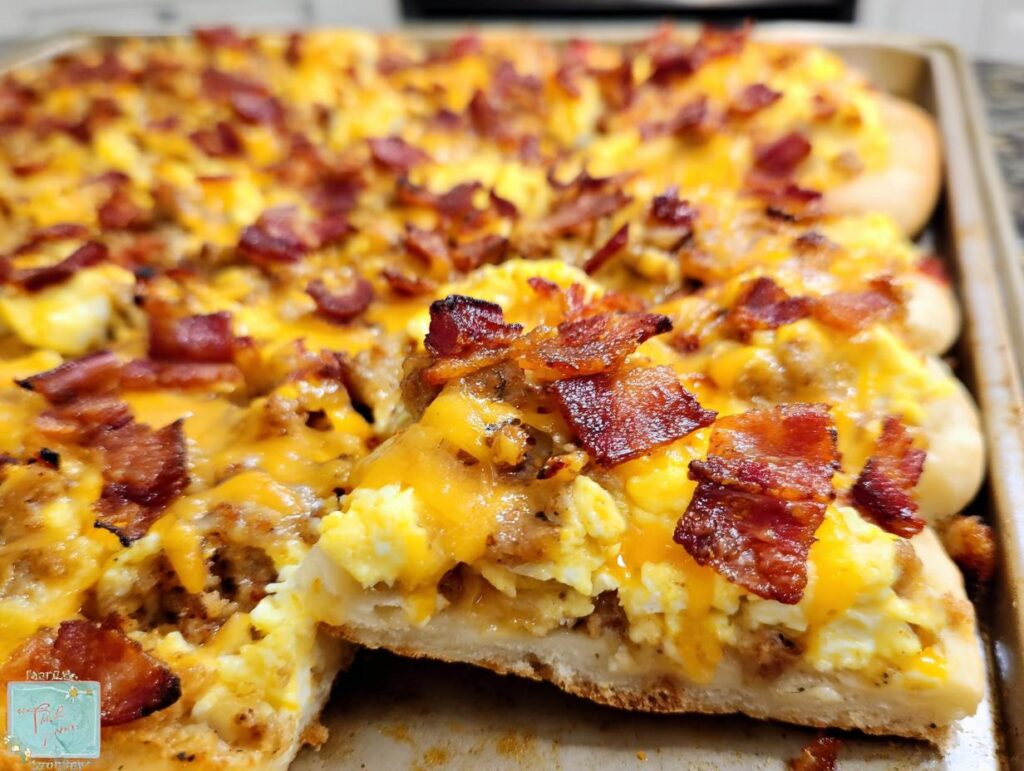 A slice of breakfast pizza egg recipe topped with scrambled eggs, cheese, and crispy bacon.