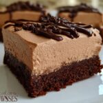 A close-up of a rich Chocolate Mousse Brownies slice, featuring a dense brownie base topped with creamy chocolate mousse and drizzled with chocolate.