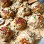 Close-up of delicious Creamy Mushroom Chicken Meatballs simmering in a rich mushroom sauce, garnished with parsley.